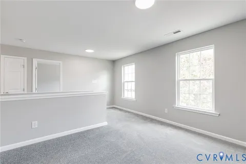 a bedroom with a bed a desk and chair with window