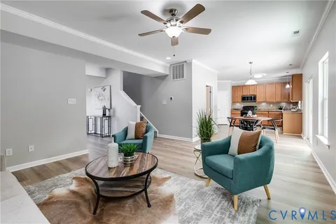 a living room with furniture and a wooden floor