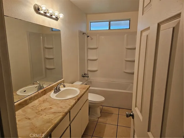 a bathroom with a granite countertop sink toilet mirror and shower