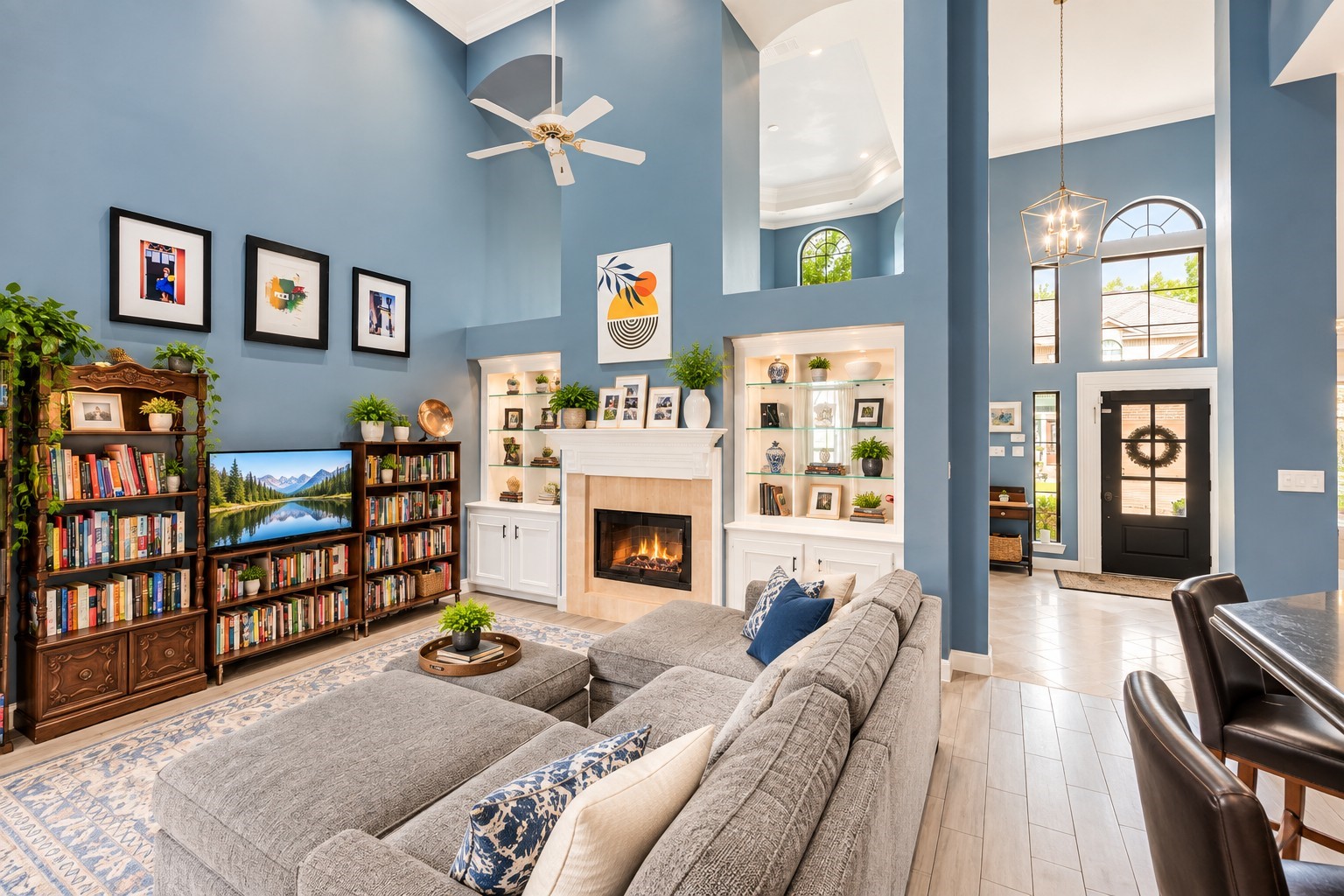Spacious living area with high ceilings, elegant built-ins, and a cozy fireplace, complemented by abundant natural light from large windows and a modern open layout.