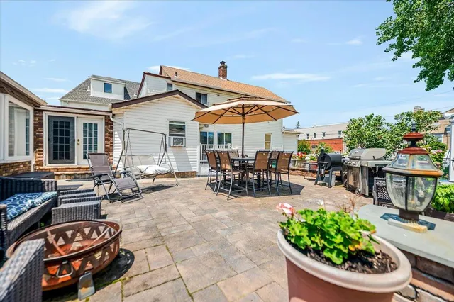 a view of a patio with dining table and chairs under an umbrella