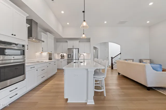a large white kitchen with lots of counter space a sink and appliances