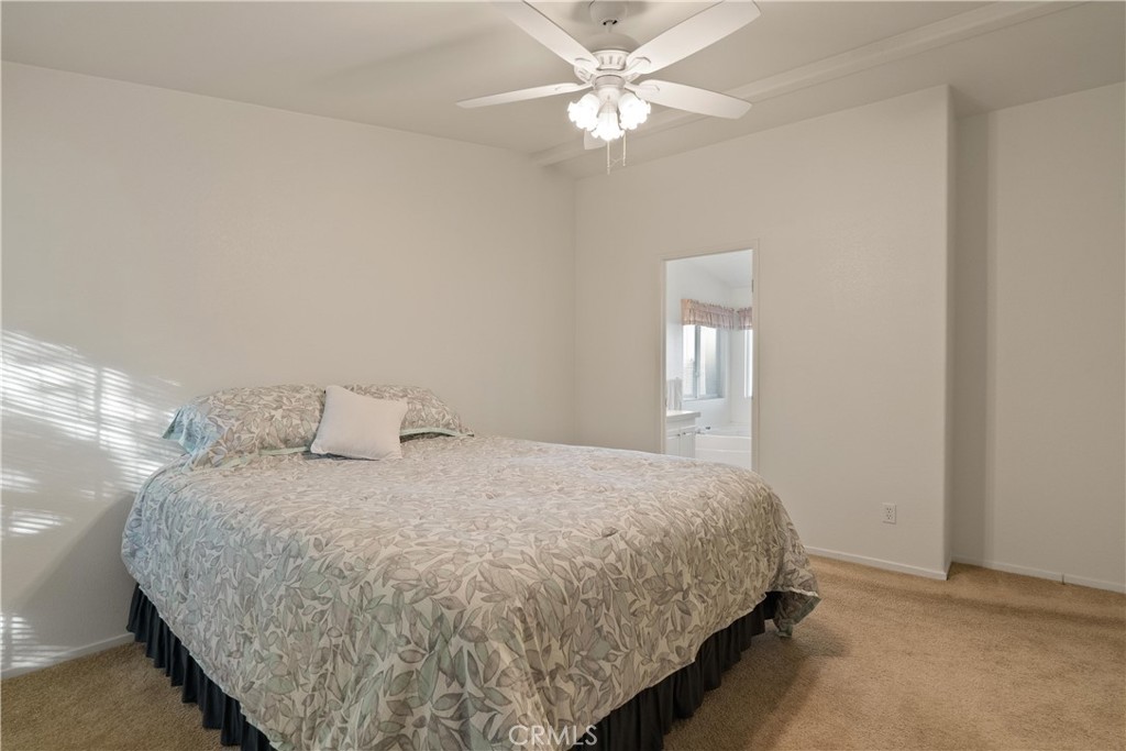 2050 Springfield Drive, Unit 143 Chico, CA 95928 - Photo 18 of 43 a bedroom with a large bed and a chandelier