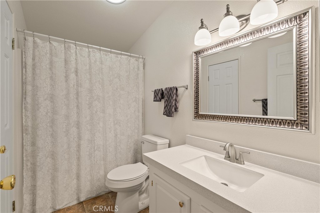 2050 Springfield Drive, Unit 143 Chico, CA 95928 - Photo 25 of 43 a bathroom with a sink a toilet and shower curtain