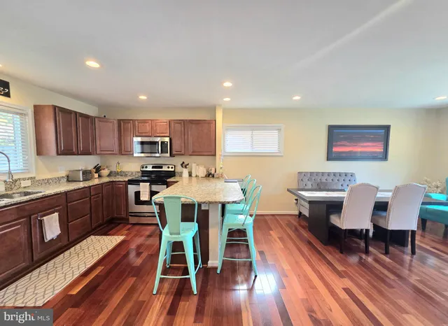 a view of a dining room with furniture a rug and wooden floor