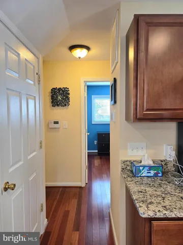 a kitchen with granite countertop wooden cabinets and wooden floor