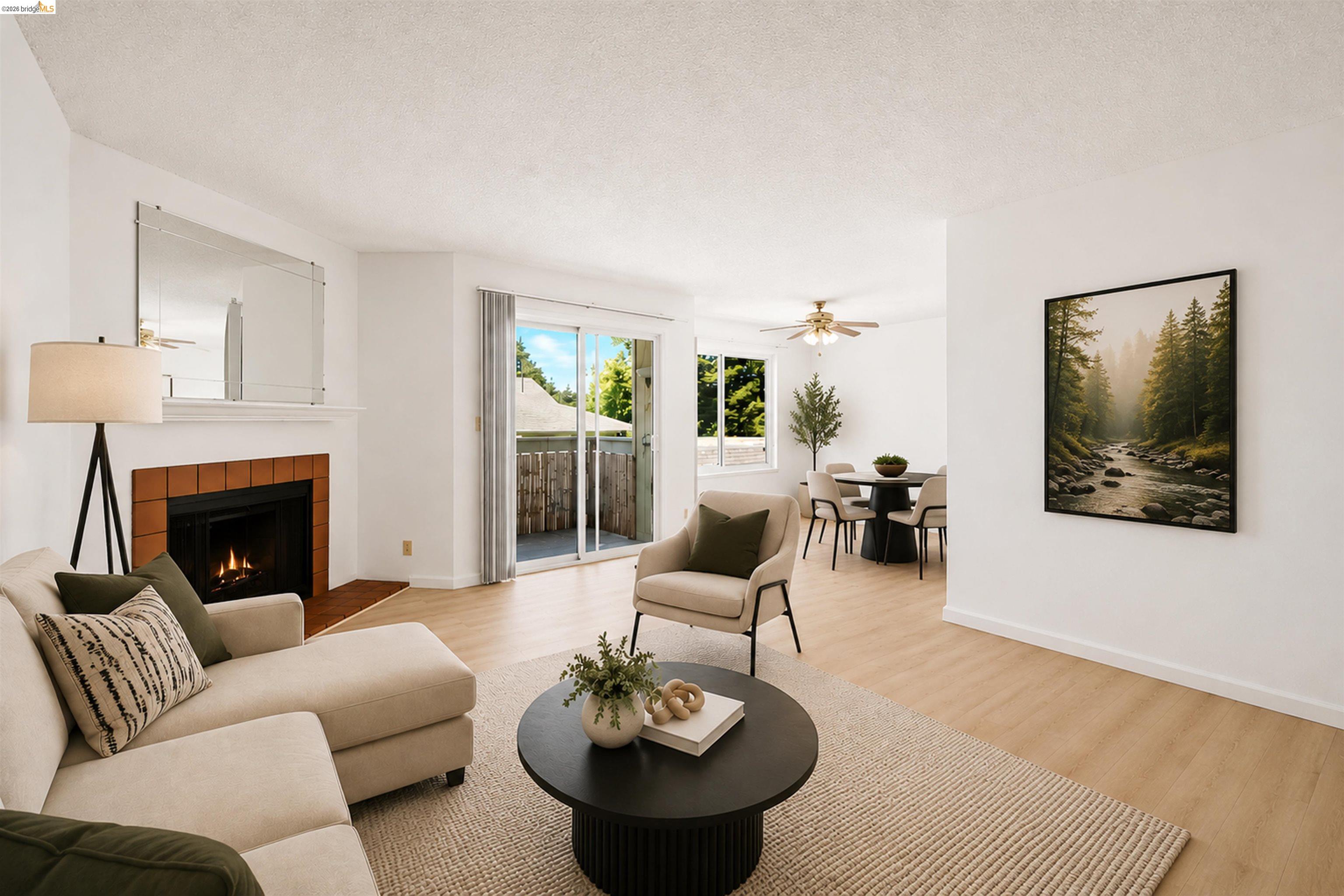4186 San Pablo Dam Road, Unit A El Sobrante, CA 94803 - Photo 8 of 34 Open-concept living space featuring wood-finish flooring, a fireplace with a terra cotta tile surround, and a glass sliding door opening to a private balcony