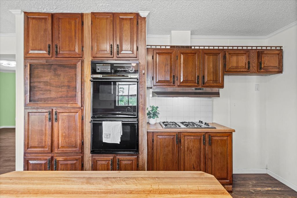 13501 Nutty Brown Road, Unit B Austin, TX 78737 - Photo 13 of 29 A well-appointed kitchen features rich wood cabinetry and essential cooking appliances.