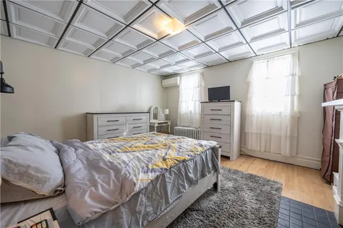a bedroom with a bed a dresser and a flat screen tv