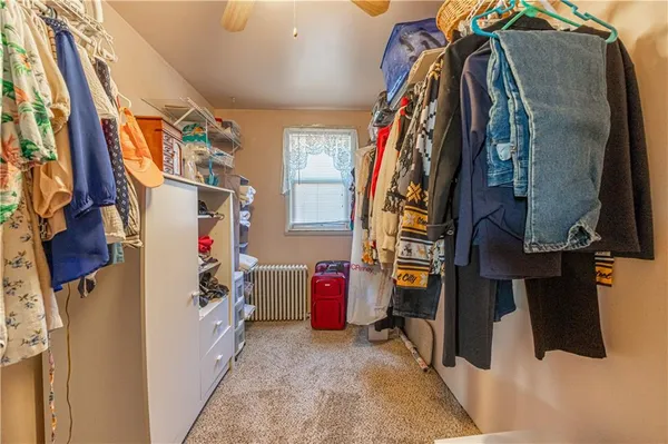 a view of walk in closet with clothes and shoes