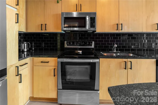 a kitchen with a sink a counter top space and a view of living room