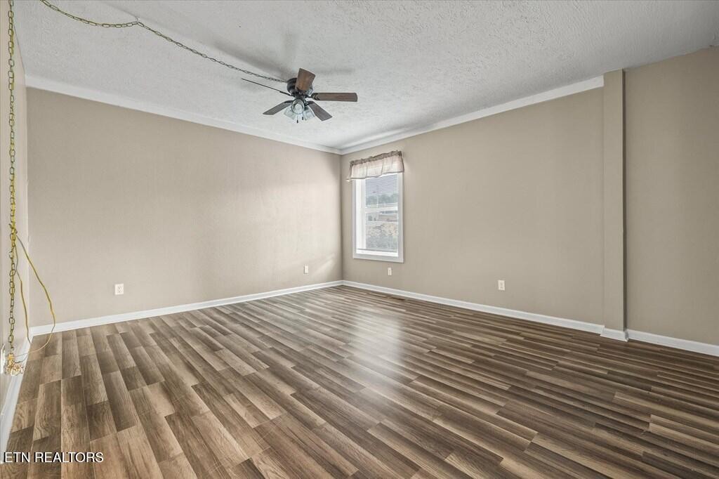 518 Flatt Spur Road Jamestown, TN 38556 - Photo 23 of 30 a view of an empty room with wooden floor and a ceiling fan