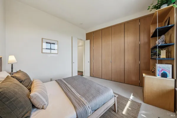 a bedroom with a bed and a couch next to a window