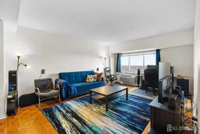 a living room with furniture a flat screen tv and a rug