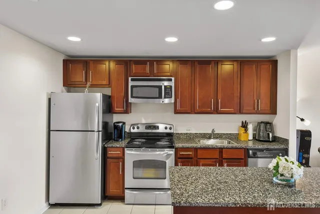 a kitchen with stainless steel appliances granite countertop a refrigerator sink and stove