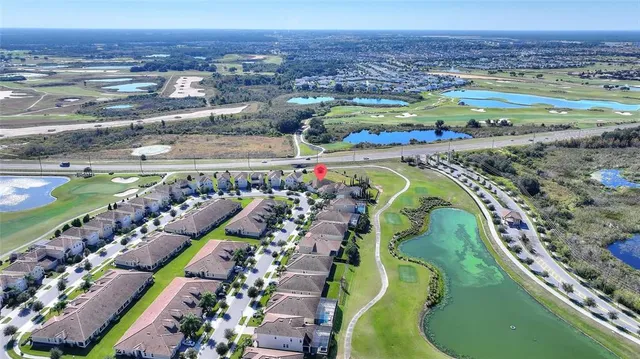 a view of a hallway with wooden floor and a bathroom