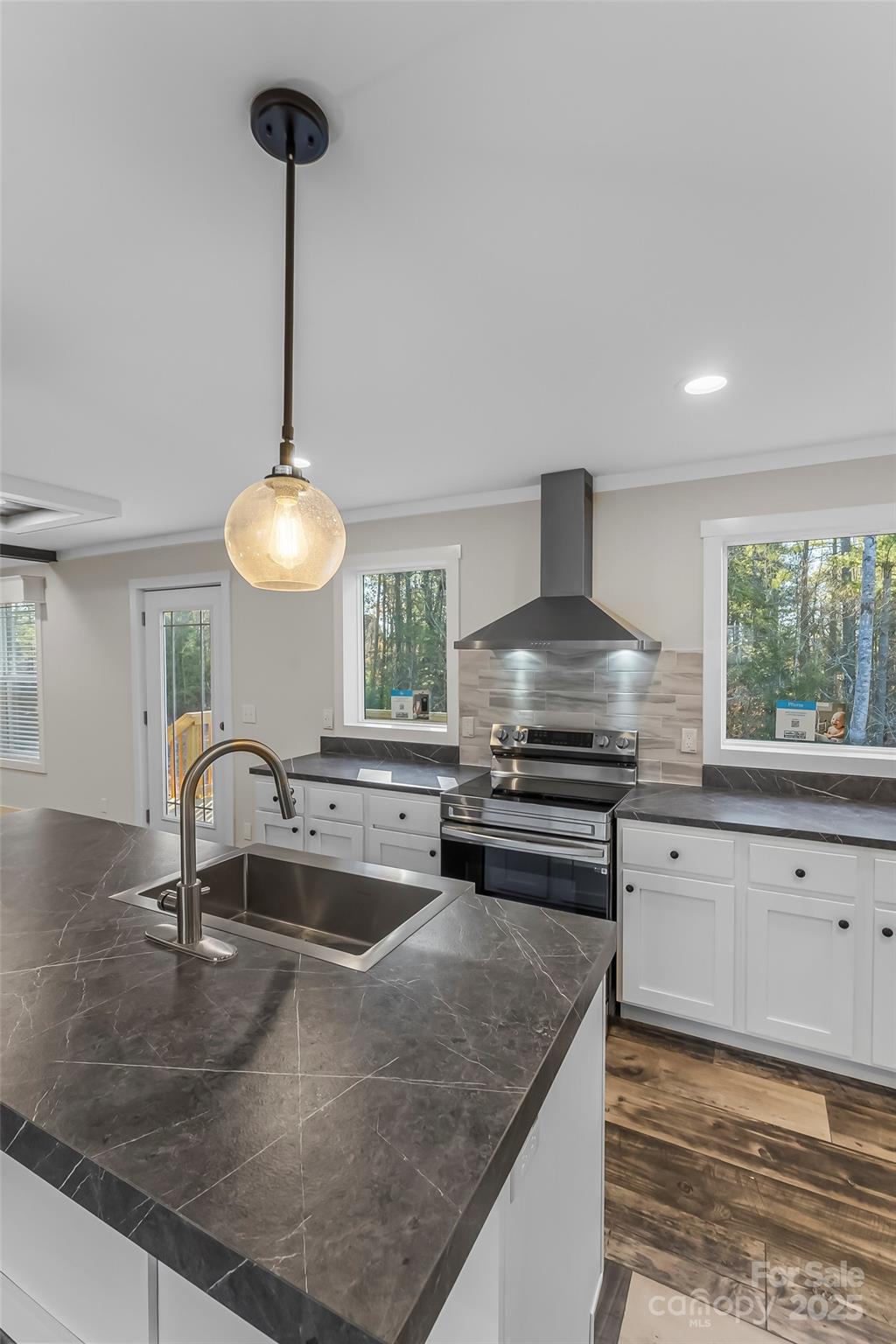 209 Walnut Br Road Weaverville, NC 28787 - Photo 13 of 43 a kitchen with stainless steel appliances granite countertop a sink a stove and a wooden floor