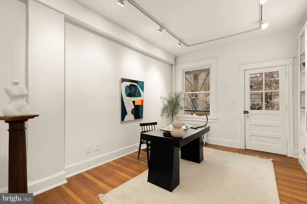 a dining room with furniture potted plants and wooden floor