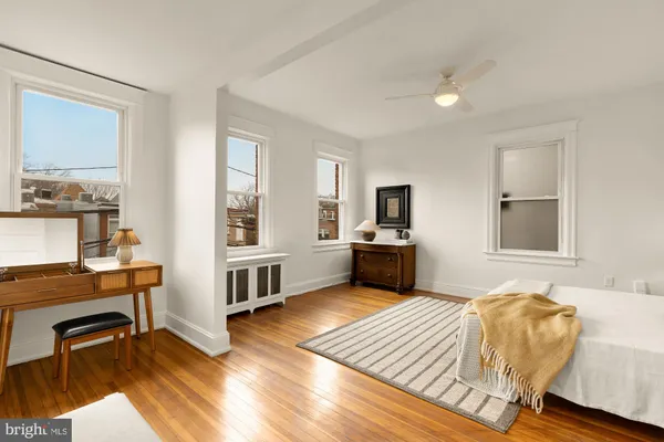 a view of a hallway with wooden floor and bathroom