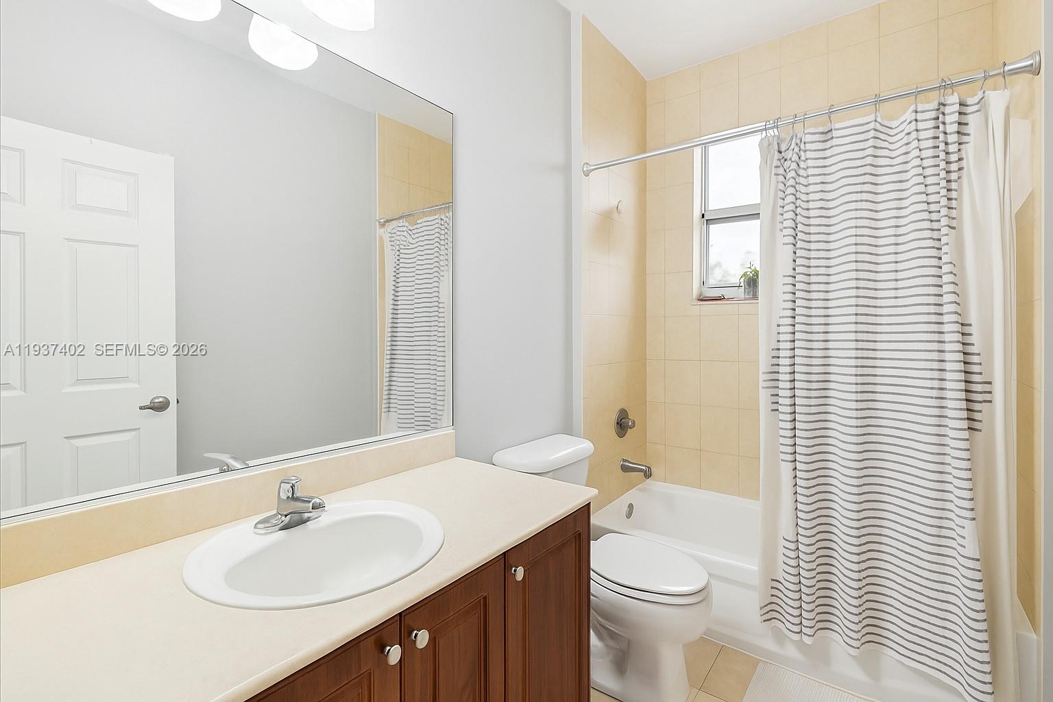 2730 Southwest 26th Street, Unit 2730 Miami, FL 33133 - Photo 14 of 21 a bathroom with a sink a toilet and shower curtain