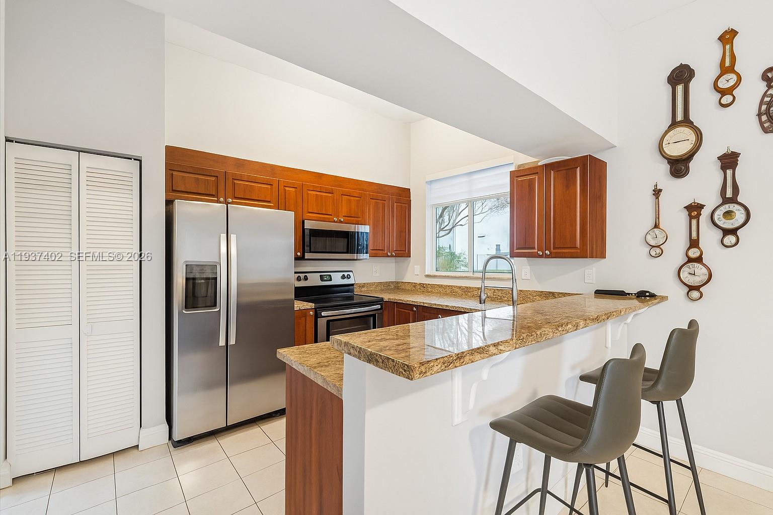 2730 Southwest 26th Street, Unit 2730 Miami, FL 33133 - Photo 8 of 21 a kitchen with stainless steel appliances granite countertop a sink and a refrigerator