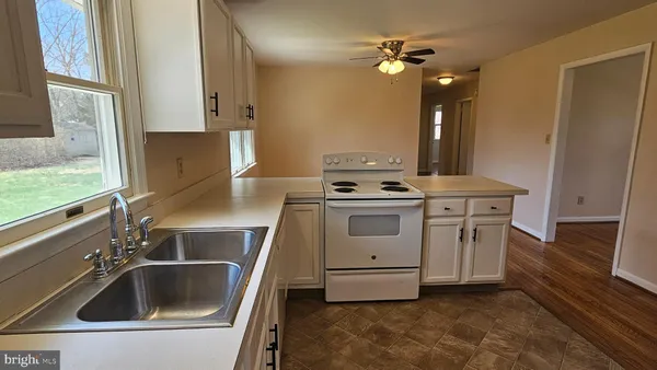 a kitchen with cabinets appliances a sink and a window