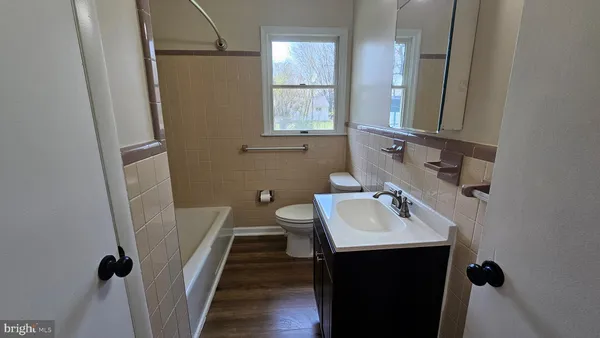 a bathroom with a sink a bathtub and a window