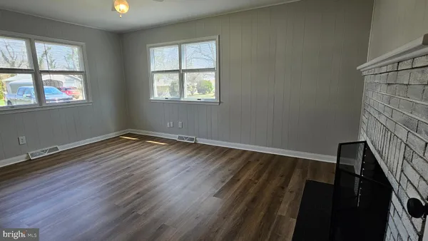a view of empty room with wooden floor and fireplace