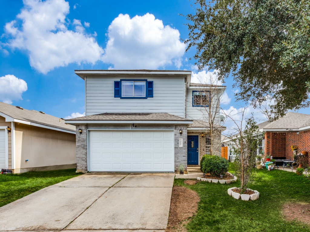a front view of a house with a yard and garage