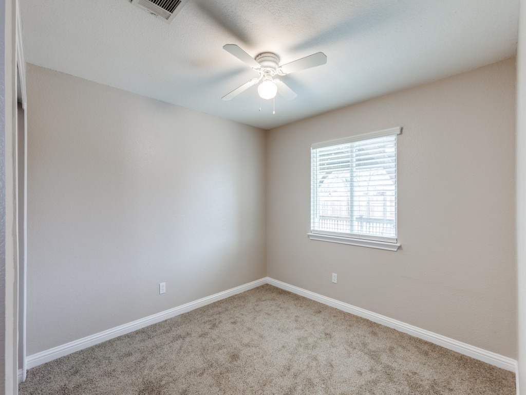 3005 Crownover Street Austin, TX 78725 - Photo 11 of 25 an empty room with a ceiling fan and windows