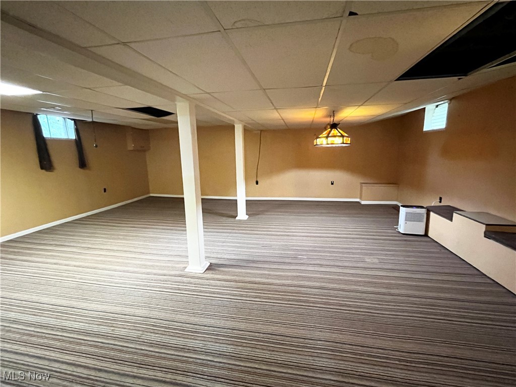 2300 River Road Willoughby, OH 44094 - Photo 25 of 28 Basement featuring a paneled ceiling, plenty of natural light, and carpet floors