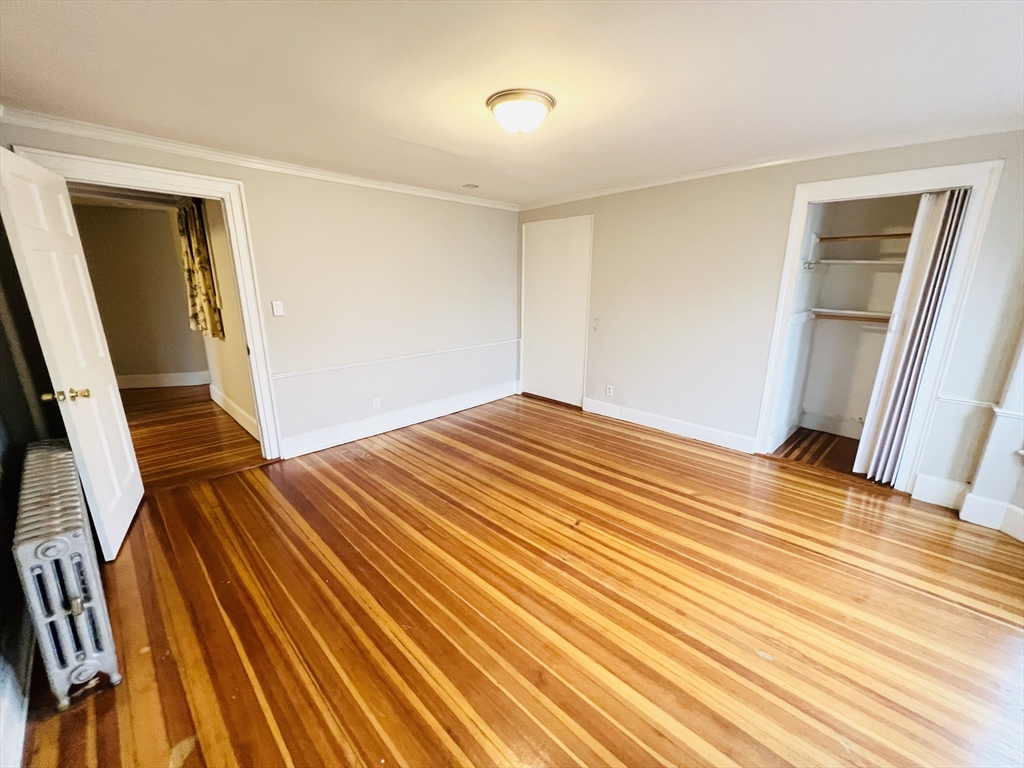 69 Adams Street, Unit 2 Boston, MA 02122 - Photo 5 of 5 a view of an empty room with wooden floor and a window