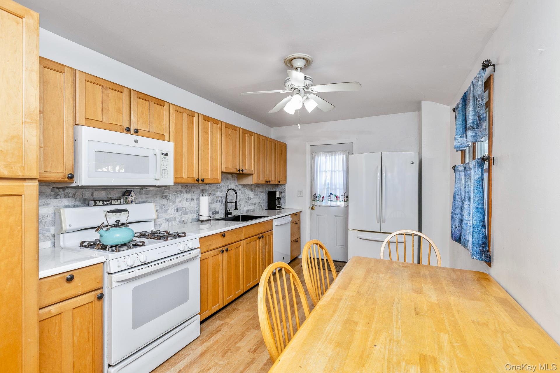 6 Talbot Lane Selden, NY 11784 - Photo 4 of 12 a kitchen with stainless steel appliances granite countertop a sink stove and refrigerator