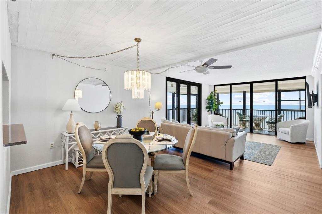 15462 Gulf Boulevard, Unit 601 Madeira Beach, FL 33708 - Photo 10 of 40 a view of a dining room with furniture a chandelier and wooden floor