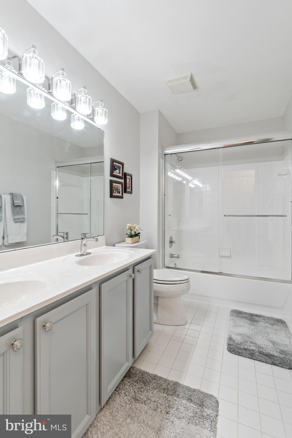 2803 Shadowridge Drive Olney, MD 20832 - Photo 25 of 55 a bathroom with a double vanity sink a toilet and a mirror