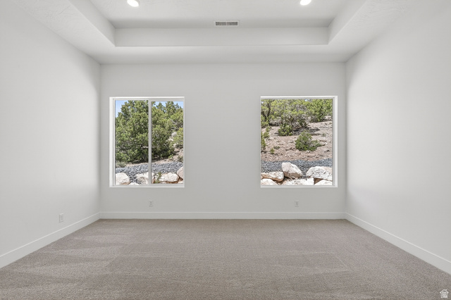 2862 South Mountain Rnch Road Cedar City, UT 84720 - Photo 22 of 64 Recessed lighting illuminates a spacious room featuring two large windows, a tray ceiling, and neutral-toned carpet flooring
