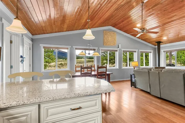 a kitchen with granite countertop a stove a sink and dishwasher wooden cabinets with granite countertops