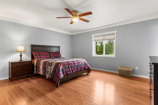 a bedroom with a bed and a ceiling fan