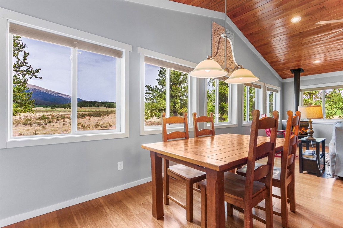 485 High Creek Road Fairplay, CO 80440 - Photo 3 of 32 a dining room with wooden floor a chandelier a wooden table and chairs