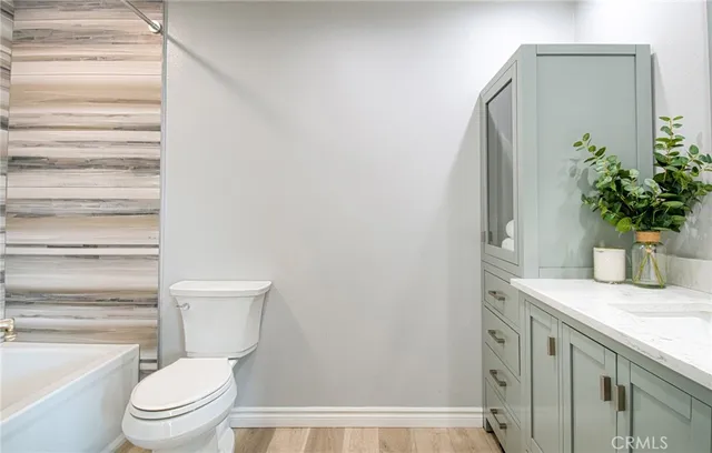 a bathroom with a granite countertop toilet and a sink