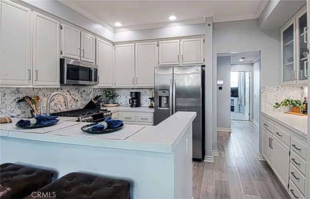 a kitchen with stainless steel appliances a refrigerator a sink a stove and cabinets