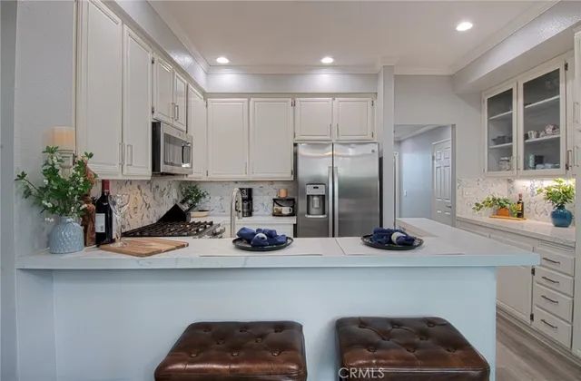 a kitchen with stainless steel appliances granite countertop a refrigerator a stove and a wooden floors