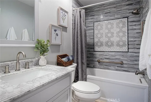 a bathroom with a granite countertop sink a toilet and shower