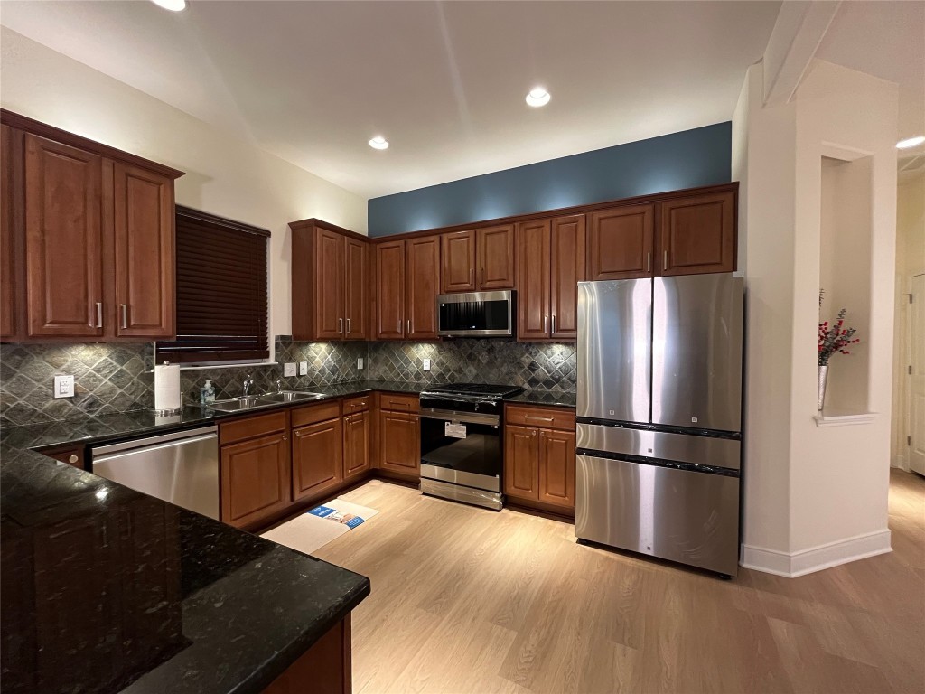 2210 Onion Creek Parkway, Unit 604 Austin, TX 78747 - Photo 1 of 15 a kitchen with granite countertop stainless steel appliances and wooden cabinets
