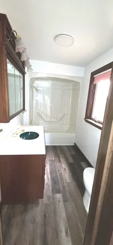 a bathroom with a toilet a sink and a window