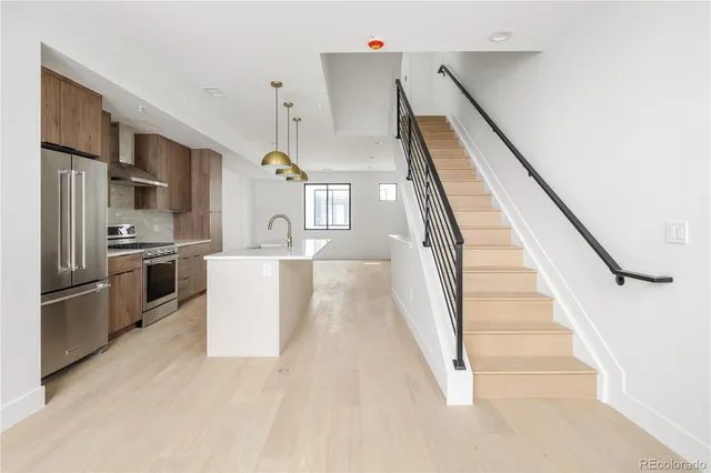 a view of a kitchen with furniture and stainless steel appliances