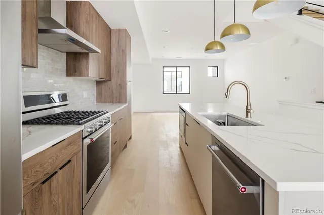 a kitchen with stainless steel appliances granite countertop a sink and a stove