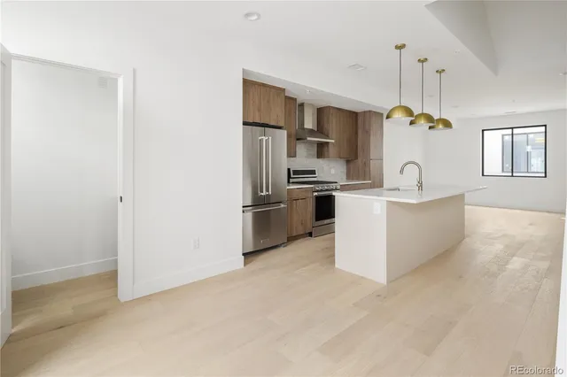 a kitchen with stainless steel appliances a refrigerator a sink a stove a microwave a dining table and chairs