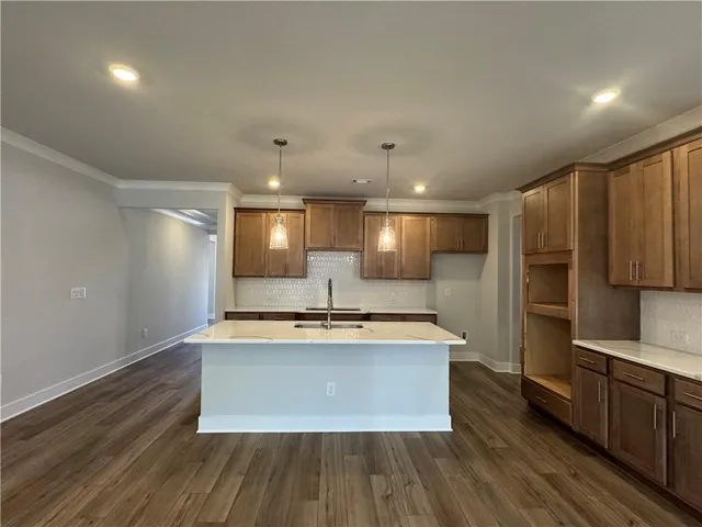 a large kitchen with stainless steel appliances a large counter top and a stove