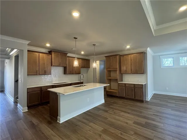 a large kitchen with stainless steel appliances kitchen island a large counter top and a wooden floors